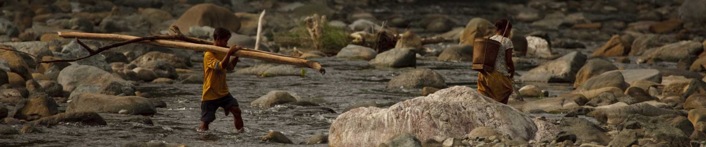 man carrying lumber across river