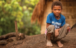 Young boy crouching on ground