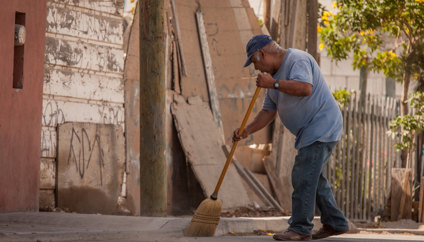 Man sweeping the sidewalk