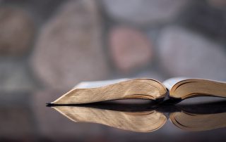 open Bible on a reflective table