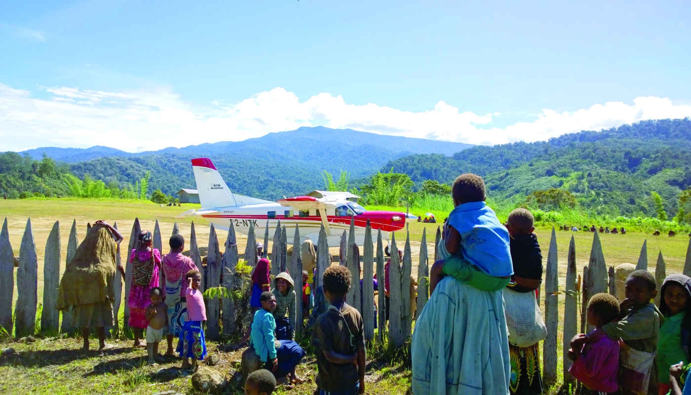 Women and children watch Kodiak plane land