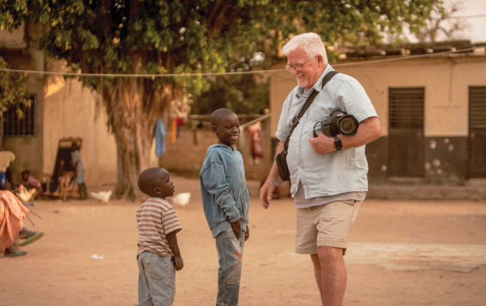 man with camera talks to African boys