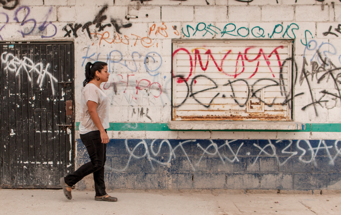 Girl walking in front of wall with graffiti