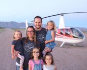 man and woman with their 4 daughters in Arizona with a helicopter in the background