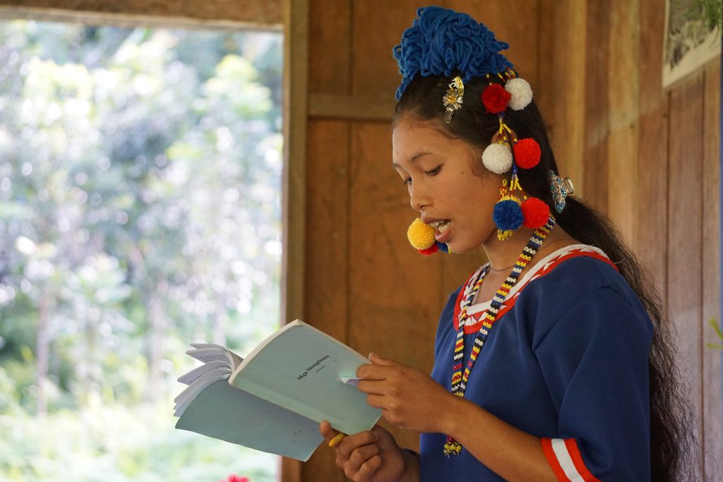 a Tala-andig graduate reads from a portion of the Bible in her own language