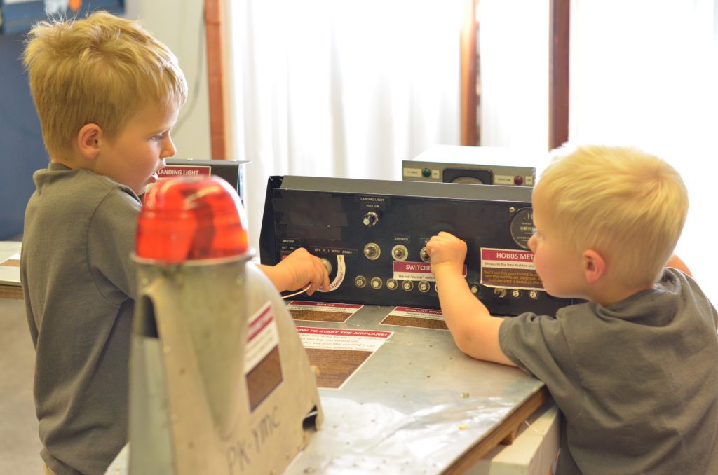 kids playing with airplane light switches