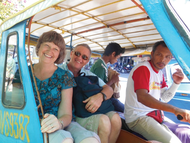 Missionaries riding a three-wheeled taxi