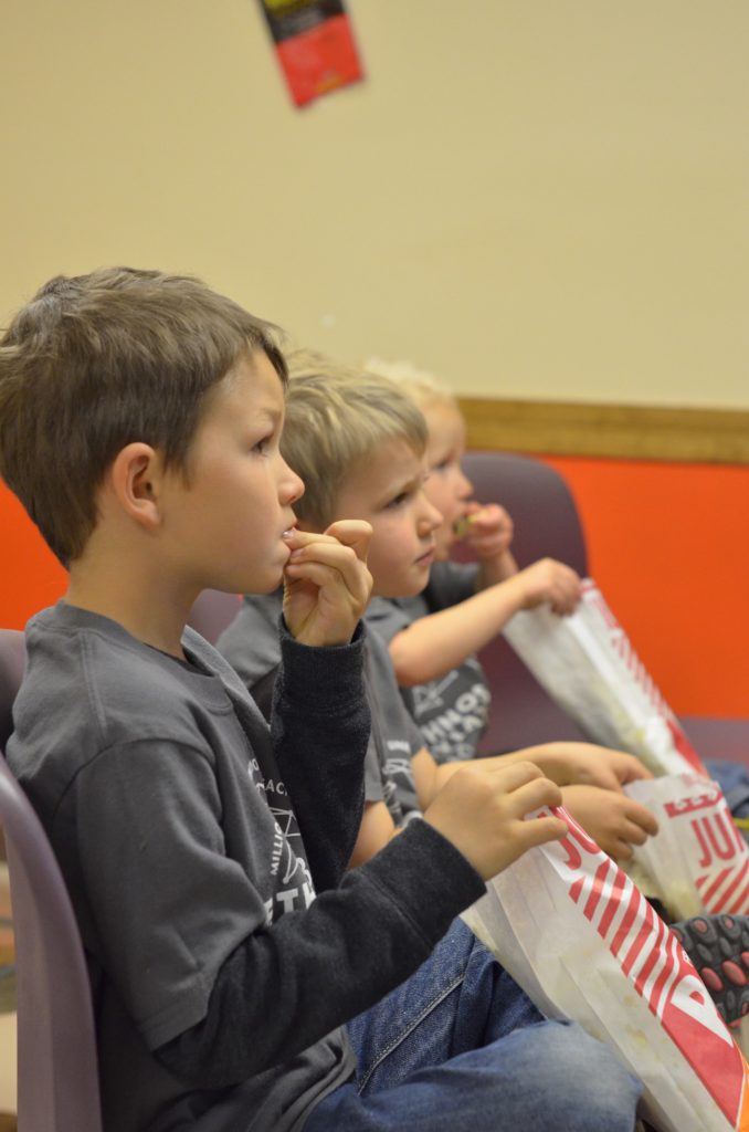 kids watching mission aircraft at work in the Mission Theatre – complete with popcorn