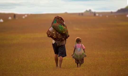 woman and child carrying goods in string bags