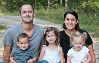 Shaiebly family sitting near the woods at Ethnos Canada