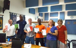 African literacy materials being shown off by missionaries and their friends