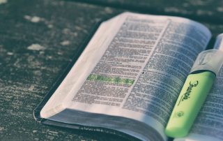 open Bible on a wooden surface with highlighter