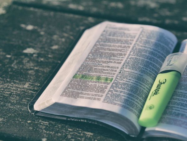 open Bible on a wooden surface with highlighter