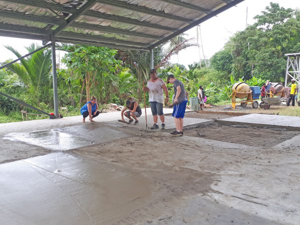 missions trip team members pouring a concrete floor for a building