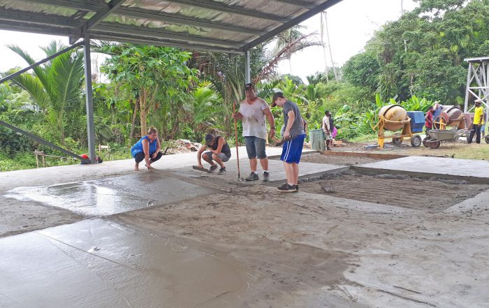 missions trip team members pouring a concrete floor for a building