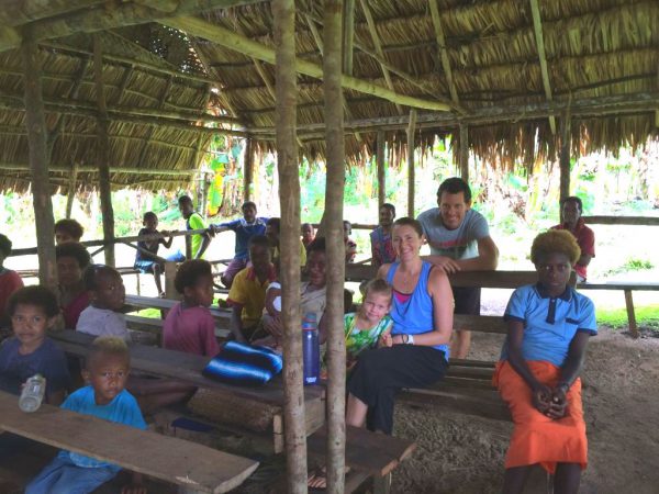 missionaries with locals under a grace roofed shelter