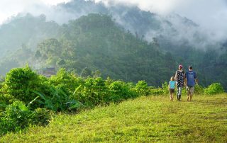 missionary woman and her kids walking near the edge of a mist shrouded valley in Papua New Guinea