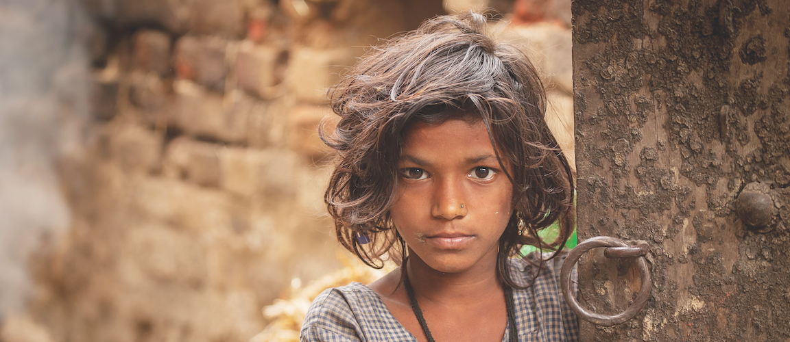 Nepalese girl standing by a brick wall