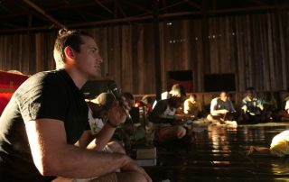 missionary teaching a Bible lesson in a dark, wood-panelled classroom