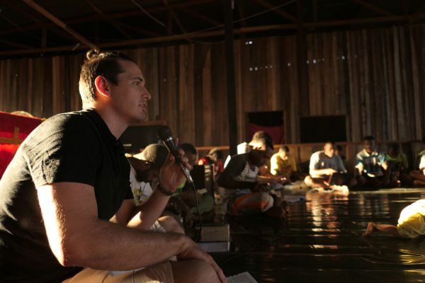 missionary teaching a Bible lesson in a dark, wood-panelled classroom