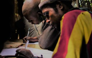 two men practicing reading and writing