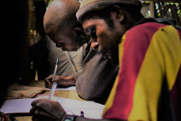 two men practicing reading and writing