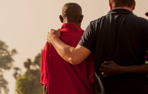 western missionary hugging two African missionaries