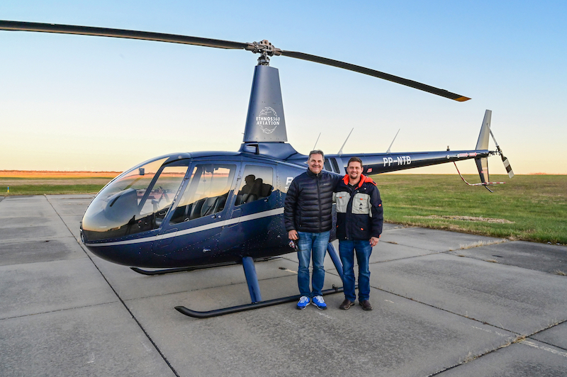 pilots standing by new helicopter before leaving for Brazil