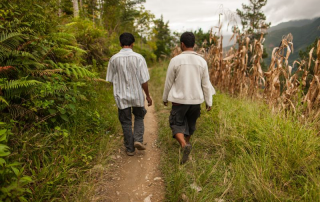 two men walk on mountain trail