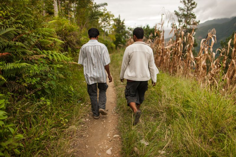 two men walk on mountain trail