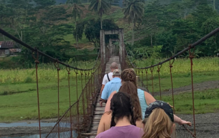 Encounter participants crossing a rope bridge