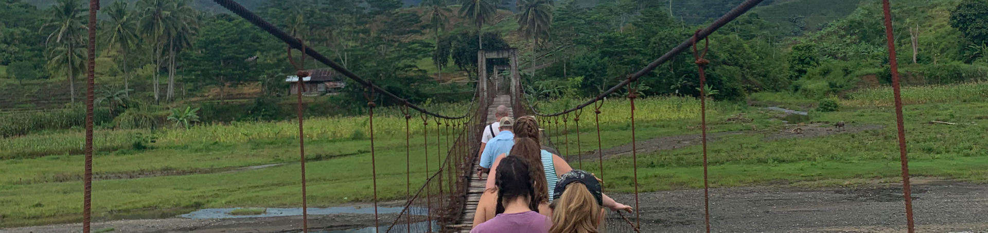 Encounter participants crossing a rope bridge