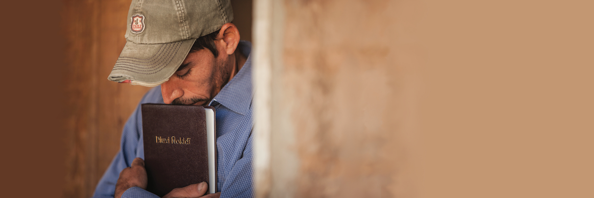 man hugging Bible