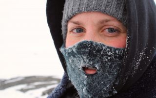 woman wearing hat, hood and mask against the cold