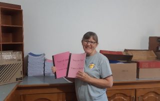 a missionary holding up newly printed books