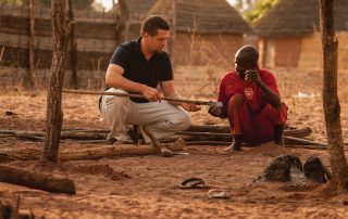 African man describes the use of a farming implement to a missionary in culture study