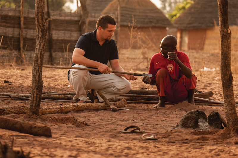 African man describes the use of a farming implement to a missionary in culture study