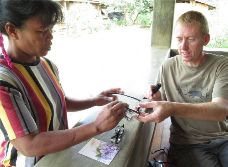 Grant Bayfield handing glasses to Manobo woman