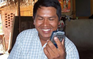 man smiles while holding audio Bible