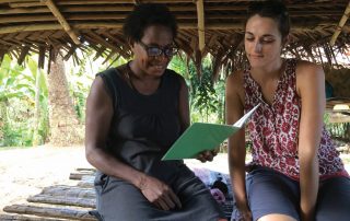 Kaje woman learning to read with missionary