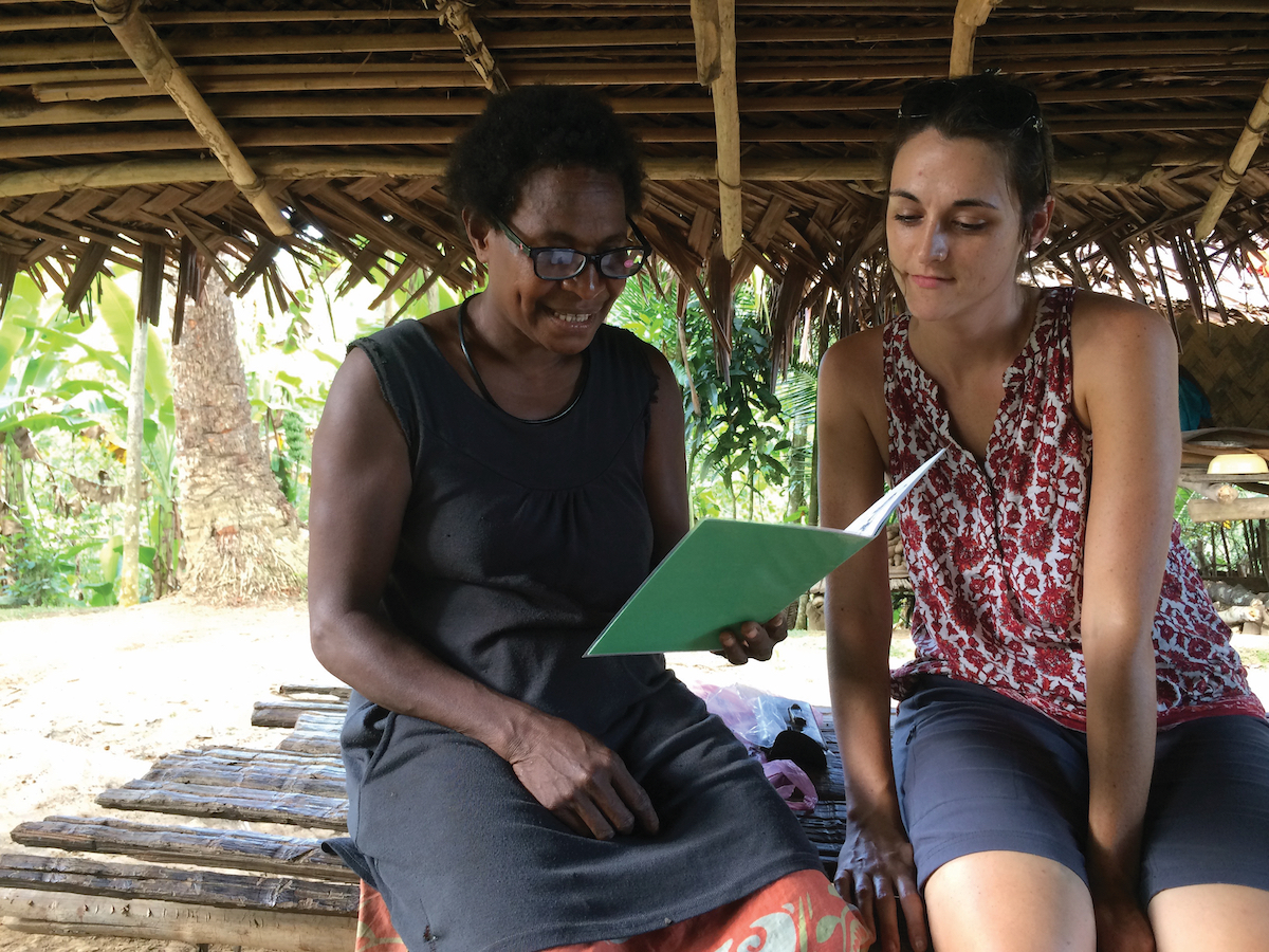 Kaje woman learning to read with missionary