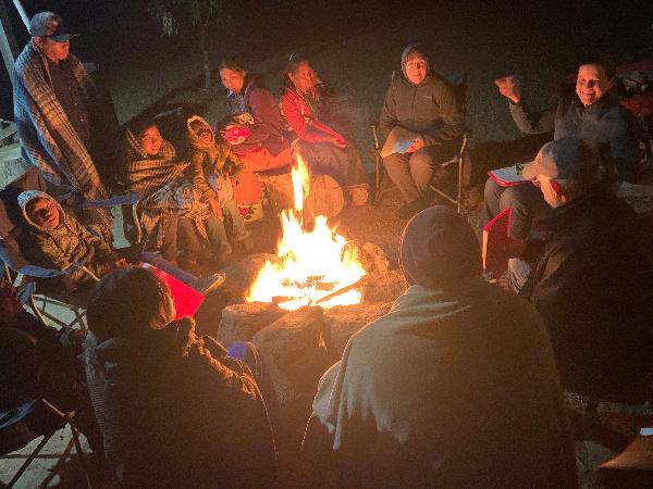 people meeting around campfire