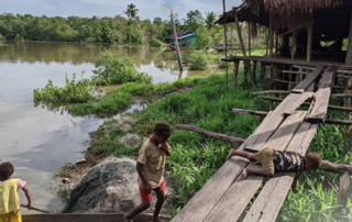 Asmat kids on the boardwalk and in a canoe